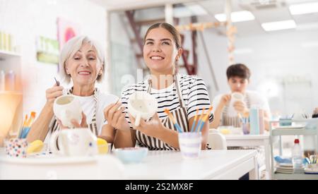 Gaies vieilles et jeunes tasses de peinture wowen dans la masterclass de poterie Banque D'Images