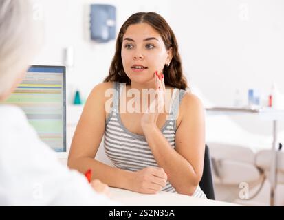 Jeune femme consultant avec une esthéticienne sans visage sur les traitements anti-âge en clinique de cosmétologie Banque D'Images