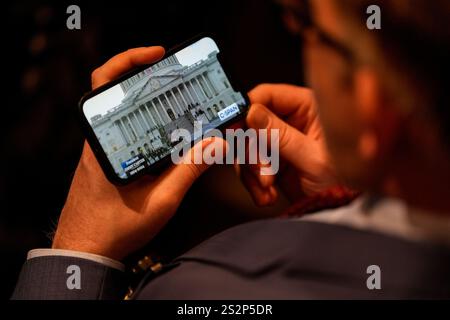 Washington, États-Unis. 07 janvier 2025. Un participant regarde un livestream C-SPAN du cercueil de l'ancien président américain Jimmy carter arriver au Capitole américain à Washington, DC, le mardi 7 janvier 2025. Carter, le 39e président, est décédé à l'âge de 100 ans le 29 décembre à son domicile de Plains, en Géorgie. Photo de la piscine par Kent Nishimura/UPI crédit : UPI/Alamy Live News Banque D'Images