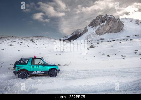 Voyage d'aventure en voiture tout-terrain 4x4 sur la montagne enneigée en hiver. Banque D'Images