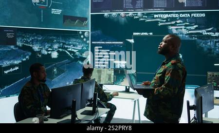 Les spécialistes militaires travaillent dans un centre de poste de commandement de haute technologie, en se concentrant sur la cybersécurité, la surveillance et la protection des données afin d’assurer la sécurité et l’intégrité des informations nationales. Caméra B. Banque D'Images
