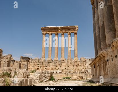 Une magnifique rangée de colonnes imposantes dans un temple antique, magnifiquement encadrée par un ciel bleu clair au-dessus en arrière-plan Banque D'Images