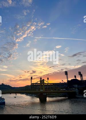 Coucher de soleil sur la rivière de la ville, les ponts et le stade. Banque D'Images