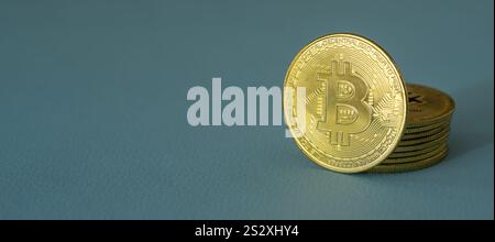 Gros plan d'une pièce de crypto-monnaie Bitcoin BTC brillante dorée sur un fond bleu Banque D'Images
