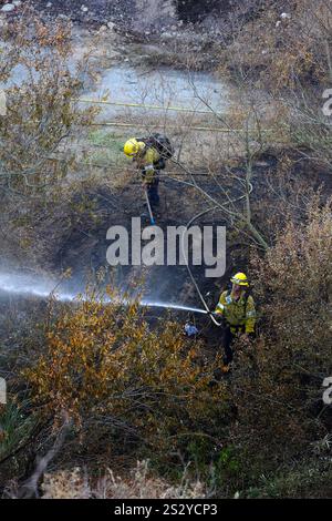 COMTÉ DE LOS ANGELES, CALIFORNIE, États-Unis - 13 décembre 2024 - les pompiers de Cal pulvérisent de l'eau sur une partie d'un canyon en feu dans le comté de Los Angeles, en Californie Banque D'Images