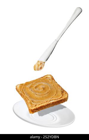 beurre d'arachide tombant du couteau sur des toasts dans une soucoupe isolée sur blanc Banque D'Images