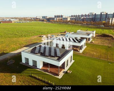 Siauliai, Lituanie, 2024 : les travailleurs de vue aérienne de haut en bas sur la surface de pose de toit se préparent à l'installation de panneaux solaires pour la maison privée. Vert Nouveau hous Banque D'Images