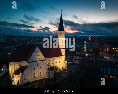 Siauliai, Lituanie - 12 novembre 2024 : vue aérienne du coucher du soleil illuminée Église catholique romaine des Saints Pierre et Paul. Siauliai City sites touristiques et Banque D'Images