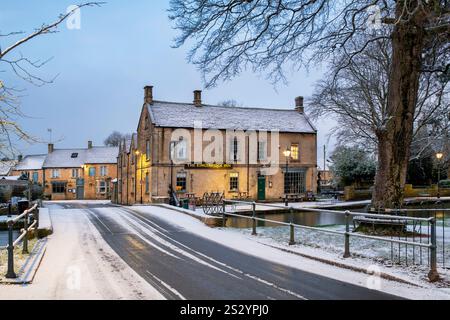 Le Kingsbridge Inn dans la neige tôt le matin. Bourton sur l'eau, Cotswolds, Gloucestershire, Angleterre Banque D'Images