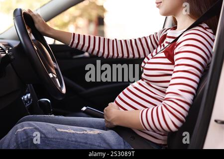 Femme enceinte avec ceinture de sécurité conduisant la voiture, gros plan Banque D'Images