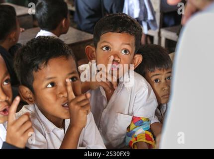 Province de Kandal, Cambodge. Jan 08,2025 : les écoliers font le signe “shh” pour faire taire la classe. Retour à l’école pour les enfants khmers dans la banlieue de Phnom Penh, plus tard que dans les autres pays d’Asie du Sud-est. Hier était un jour férié, alors que les Cambodgiens célébraient le jour de la victoire sur le génocide le 7 janvier 1979, avec la libération de la capitale et la chute du régime de Pol pot. Bien que le pays soit majoritairement bouddhiste (93% à 97%), les vacances scolaires «d'hiver» comprennent Noël, la Journée de la paix cambodgienne le 29 décembre, le nouvel an international et le jour de la victoire. Crédit : Kevin Izorce/Alamy Live News Banque D'Images