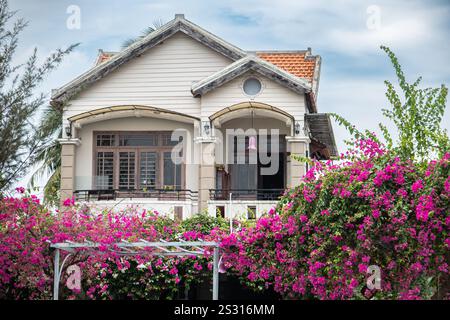 Élégante maison entourée de bougainvilliers roses luxuriants, façade d'une grande maison avec beau jardin Banque D'Images