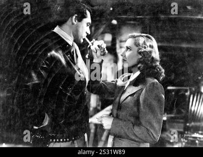 SEULS LES ANGES ONT DES AILES Cary Grant et Jean Arthur allumant des cigarettes date : 1939 Banque D'Images