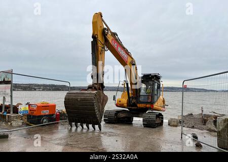 Une excavatrice jaune du projet de protection côtière de Mumbles vue à Southend. Mumbles, Swansea, pays de Galles, Royaume-Uni. 8 janvier 2025. Banque D'Images