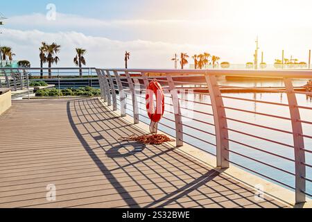 Promenade au bord de l'eau avec Lifebuoy et Sunny View Banque D'Images