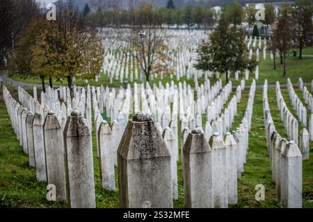 Le cimetière comporte un grand nombre de tombes, chacune marquée par des pierres tombales, avec des arbres luxuriants debout en arrière-plan fournissant de l'ombre Banque D'Images