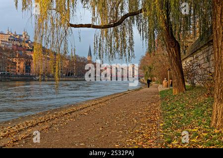 LYON, 17 décembre 2024 : coucher de soleil hivernal sur les rives de la Saône avec la basilique de Fourvière en arrière-plan. Banque D'Images