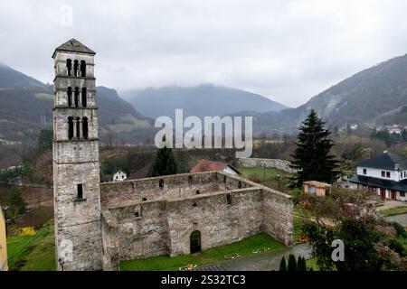 Il s'agit d'une vue aérienne impressionnante mettant en valeur un magnifique château doté d'une haute tour, avec de superbes montagnes gracieusement s'élevant en arrière-plan Banque D'Images