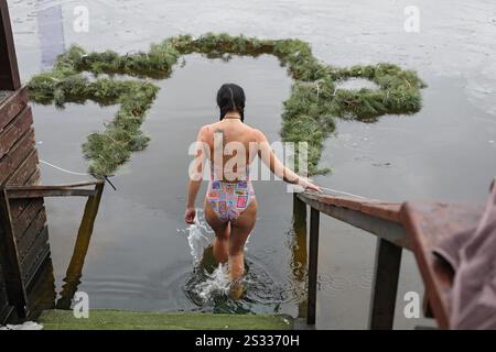Non exclusif : KIEV, UKRAINE - 6 JANVIER 2025 - Une femme descend les marches dans l'eau froide pendant le MorzhFest 2025 au X-Park sur l'Epiphanie, Banque D'Images