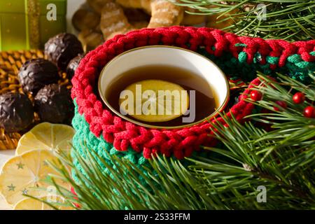 Tasse de thé au citron. Chocolats, citron séché et branches d'arbre de Noël. Carte de vacances. Banque D'Images