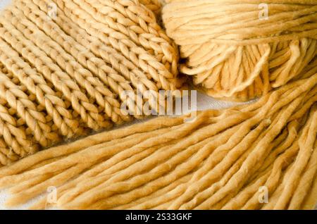 Tricot, écharpe et boule de fil jaune. Fibres synthétiques, motif tridimensionnel. Banque D'Images