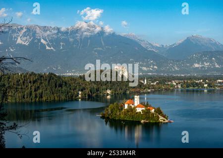 Il y a une petite île pittoresque située en plein milieu d'un lac serein, qui a des montagnes majestueuses qui se profilent en arrière-plan Banque D'Images