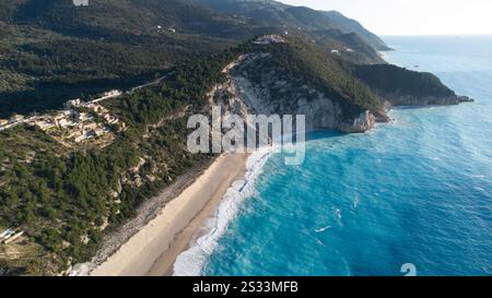 Une vue aérienne panoramique capture une plage magnifique avec des montagnes pittoresques s'élevant majestueusement en arrière-plan, le long d'une grande étendue d'eau Banque D'Images