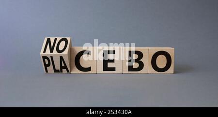 Symbole nocebo vs placebo. Cubes en bois tournés avec les mots placebo et nocebo. Beau fond gris. Concept de médecine. Copier l'espace. Banque D'Images