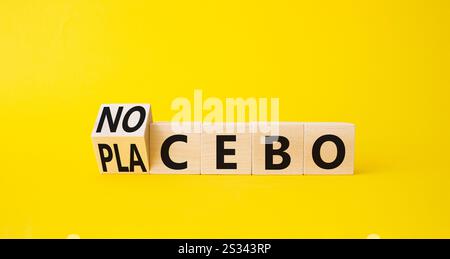 Symbole nocebo vs placebo. Cubes en bois tournés avec les mots placebo et nocebo. Beau fond jaune. Concept de médecine. Copier l'espace. Banque D'Images