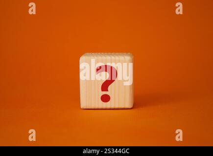 Symbole de point d'interrogation. Mots conceptuels point d'interrogation sur cube en bois. Beau fond orange. Affaires et point d'interrogation. Copier l'espace. Banque D'Images