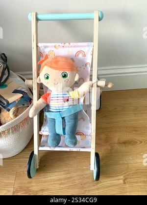 Poupée pour enfants et poussette jouer chose jouets livres lecture placard à l'intérieur du jouet bébé jouer choses chariot roues pousser poussent poussette jouets jouets jeux dessin UK Banque D'Images