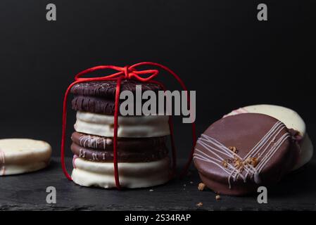 Délicieux biscuits Ischler avec glaçage au chocolat brun et blanc sur noir. Pâtisserie maison, Noël Banque D'Images