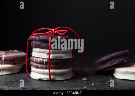 Délicieux biscuits Ischler avec glaçage au chocolat brun et blanc sur noir. Pâtisserie maison, Noël Banque D'Images