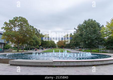 Vancouver, CANADA - septembre 30 2024 : fontaine à Martha Piper Plaza sur le campus de l'Université de Colombie-Britannique, avec feuillage d'automne avec les étudiants walki Banque D'Images