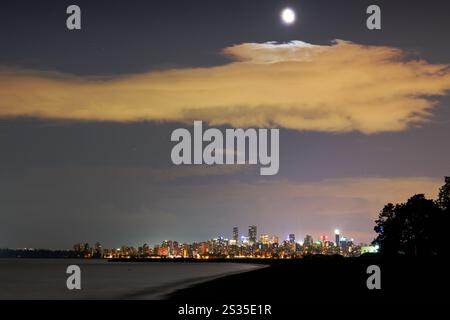 English Bay Night Vancouver Cityscape Moon. La lune se lève au-dessus de la skyline de Vancouver sur English Bay. Colombie-Britannique, Canada. Banque D'Images