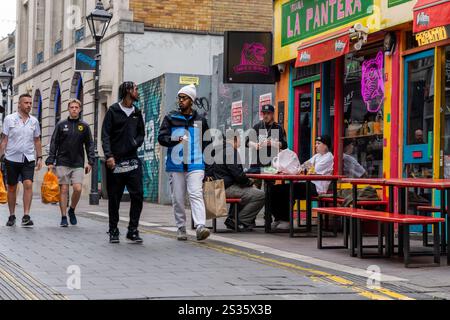 Cardiff Wales - 7 août 2024 ; les gens dînent devant le bar à tacos coloré de Quay Street tandis que les gens passent. Banque D'Images
