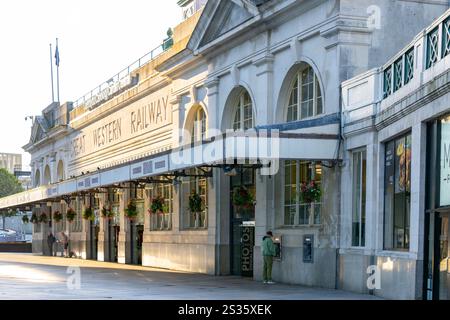 Cardiff pays de Galles - 6 août 2024 ; homme recevant de l'argent d'un distributeur automatique de billets devant la gare à la lumière du matin. Banque D'Images