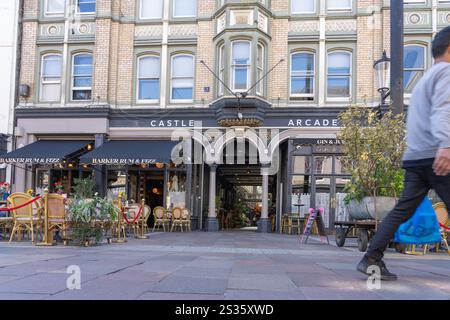 Cardiff Wales - 6 août 2024 : rue à l'extérieur et façade de Castle Arcade comme image floue de l'homme qui sort du cadre. Banque D'Images