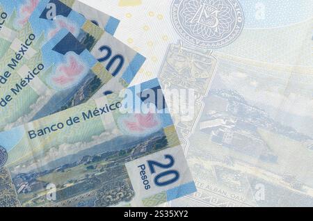 Les billets de 20 pesos mexicains sont empilés sur fond de gros billets semi-transparents. Arrière-plan commercial abstrait avec espace de copie Banque D'Images