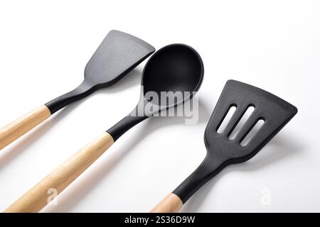 Ustensiles de cuisine en silicone avec manche en bois isolé sur fond blanc. Ensembles d'ustensiles de cuisine Banque D'Images