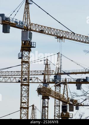 Plusieurs grues de construction sont utilisées sur un chantier de construction. Boom dans l'industrie de la construction Banque D'Images