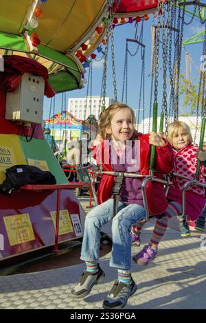 Enfant monte un carrousel à chaîne à une foire et s'amuse Autriche Banque D'Images