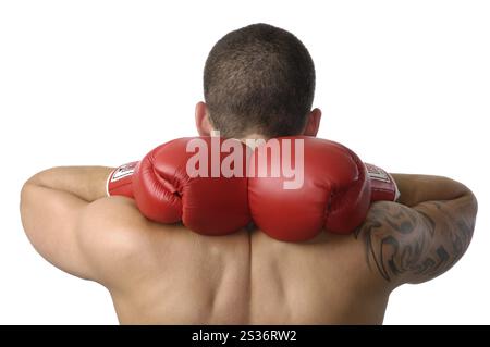 Jeune homme kickboxer portant des gants de boxe rouges avec les mains derrière son cou gros plan d'une silhouette isolée arrière sur fond blanc Banque D'Images