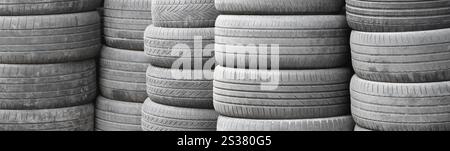 Vieux pneus usagés empilés avec des piles élevées dans le garage secondaire de magasin de pièces de voiture de près. Vieux pneus usagés empilés avec des piles élevées dans des pièces de voiture secondaires Banque D'Images