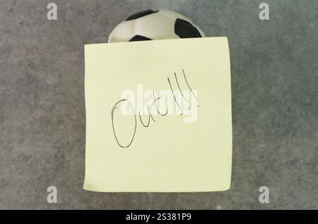 Objet de ballon de football avec note d'avertissement sportif sur des notes jaunes Banque D'Images