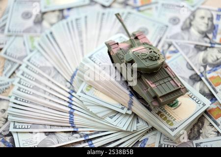 Réservoir de jouet sur les billets de banque de cent dollars US gros plan. Le concept de coûts de guerre, de dépenses militaires et de crise économique. Réservoir jouet sur US Hundred Banque D'Images