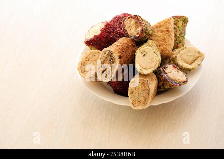 De nombreux rouleaux de plaisir turc avec différentes saveurs et garnitures dans une assiette blanche sur la table. Coupes de bonbons Turk Lokumu. Beaucoup de petits pains de plaisir turc Banque D'Images