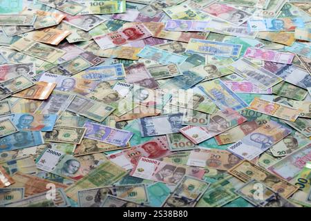 Beaucoup de billets de monnaie différente. Fond de grande quantité de factures d'argent aléatoires en gros plan. Beaucoup de billets de monnaie différente. Arrière-plan de Banque D'Images