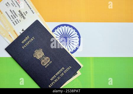 Passeport indien bleu avec des billets d'avion sur fond de drapeau gros plan. Tourisme et concept de voyage Banque D'Images