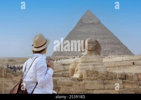 Vue arrière d'une femme portant un chapeau, regardant les grandes pyramides en Egypte Banque D'Images